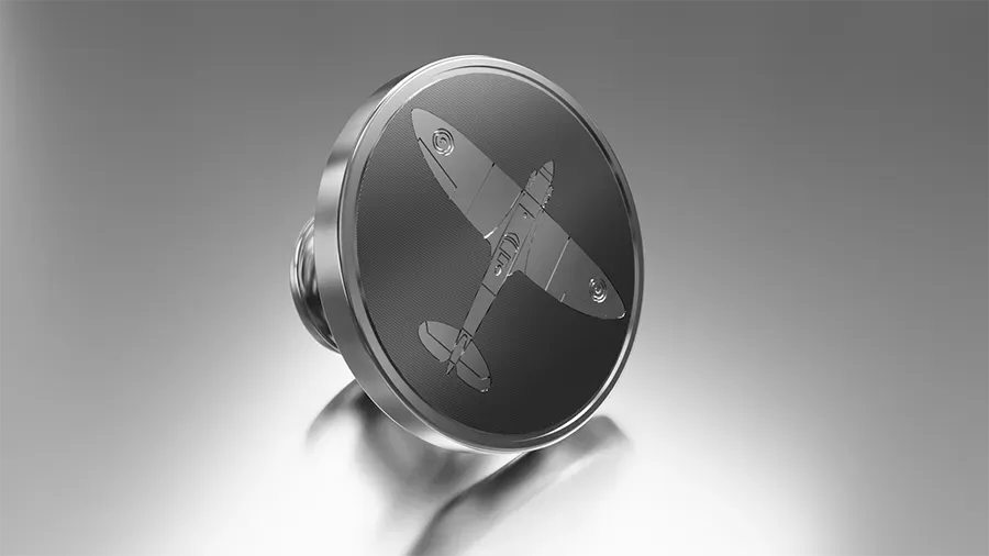 photorealistic product render of a sterling silver lapel pin with engraved detail of a spitfire plane on a textured background